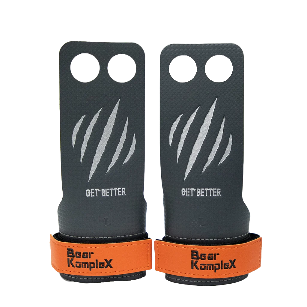 Pair of black and orange grip enhancers with 'Bear KompleX' branding on a white background