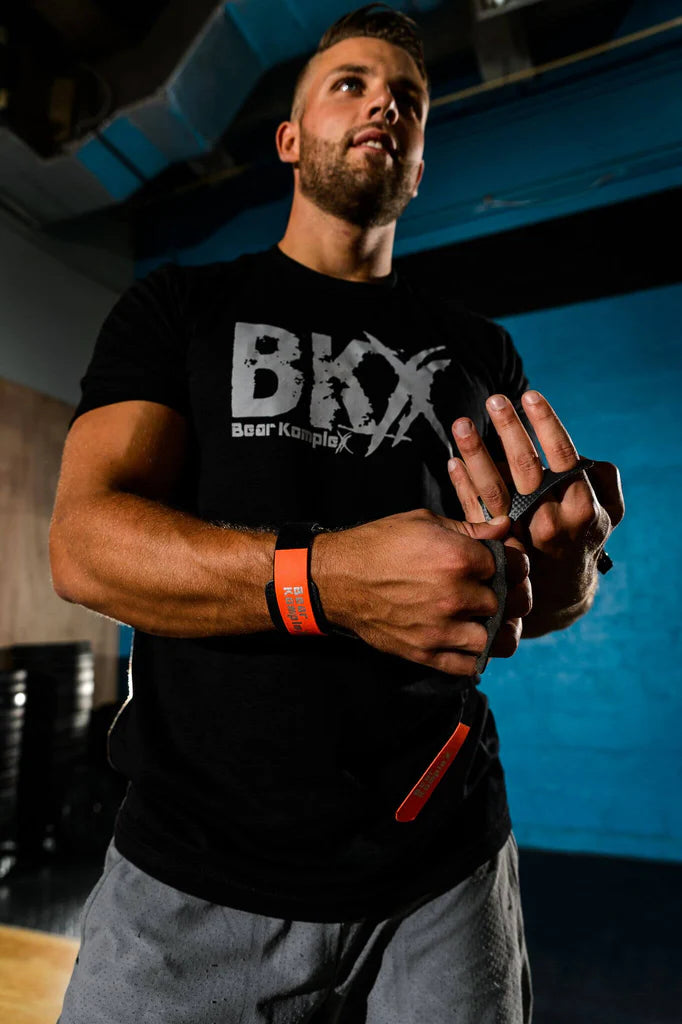 Man wearing a black t-shirt with 'BKX' logo, wearing bear complex 3 hole grips