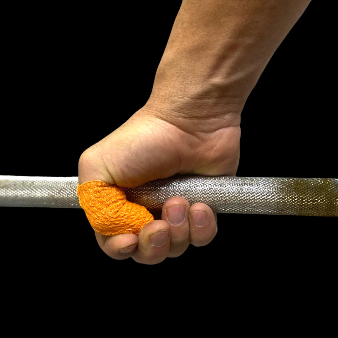 Hand holding a barbell with orange frog grip thumb tape on a black background