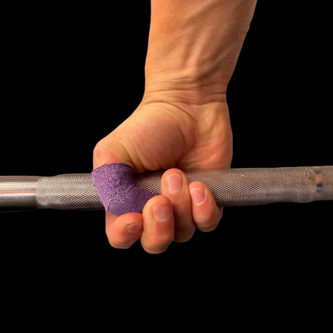 Hand holding a barbell with purple frog grip thumb tape on a black background