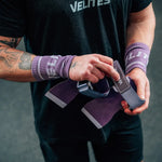 man strapping on the all terrain purple hand grips