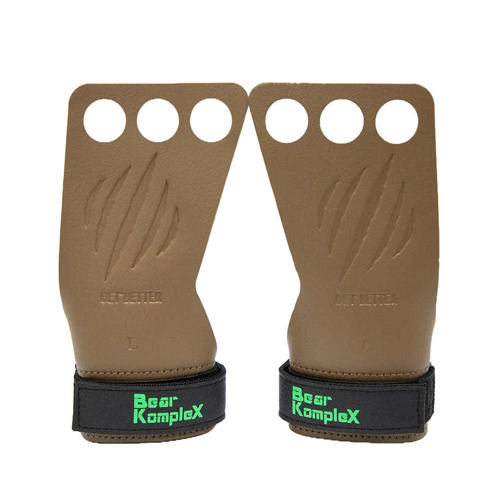 Pair of brown leather grip pads with black wrist straps and 'Bear KompleX' branding on a white background.