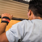 Person exercising with a barbell using bear komplex hand grips in a gym setting