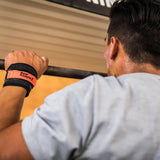 Person exercising with a barbell using bear komplex hand grips in a gym setting