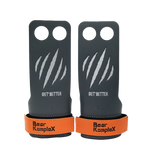Pair of black and orange grip enhancers with 'Bear KompleX' branding on a white background