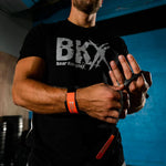 Man wearing a black t-shirt with 'BKX' logo, wearing bear complex 3 hole grips
