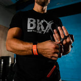 Man wearing a black t-shirt with 'BKX' logo, wearing bear complex 3 hole grips