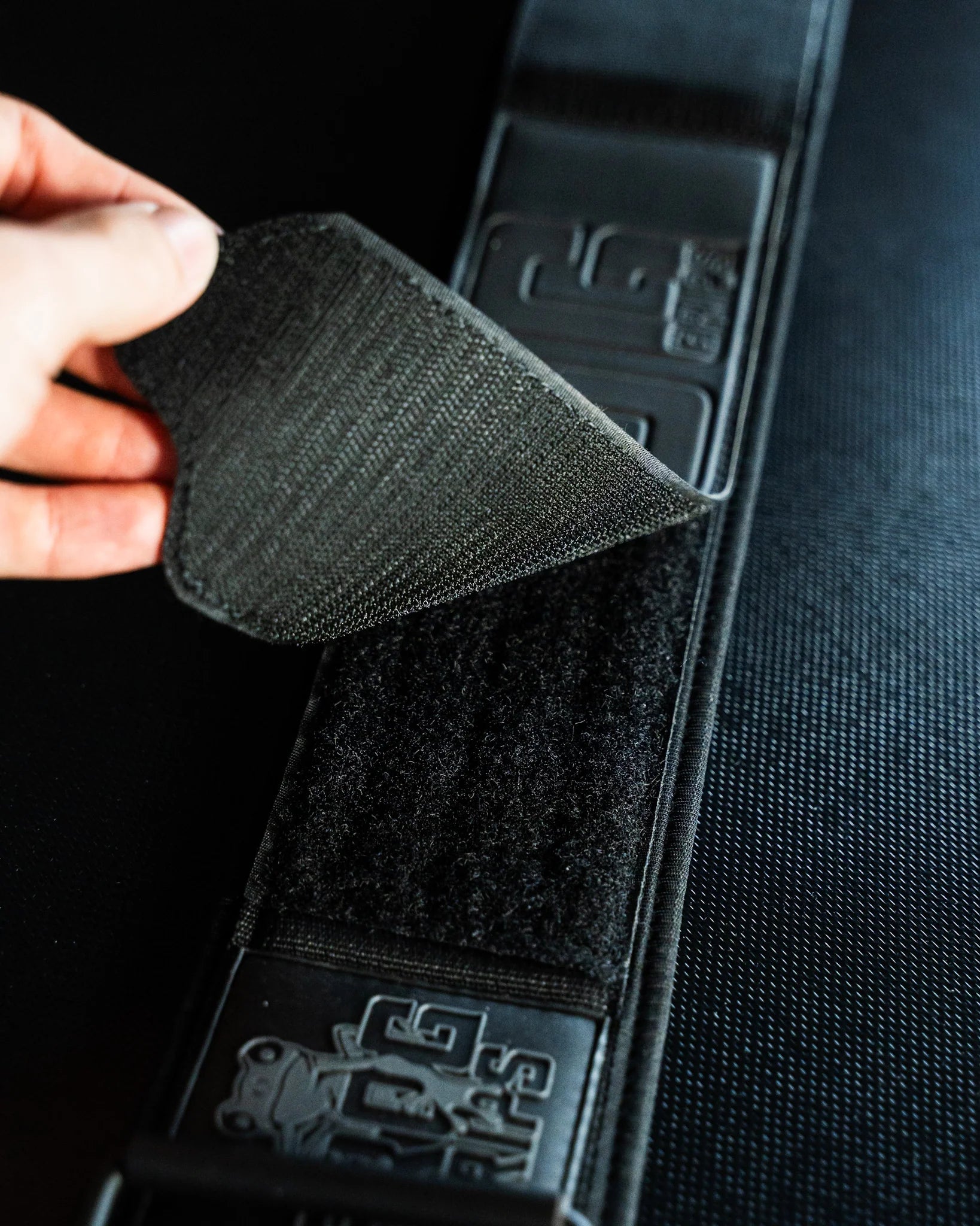 Black velcro patch being attached to a frog lifting belt