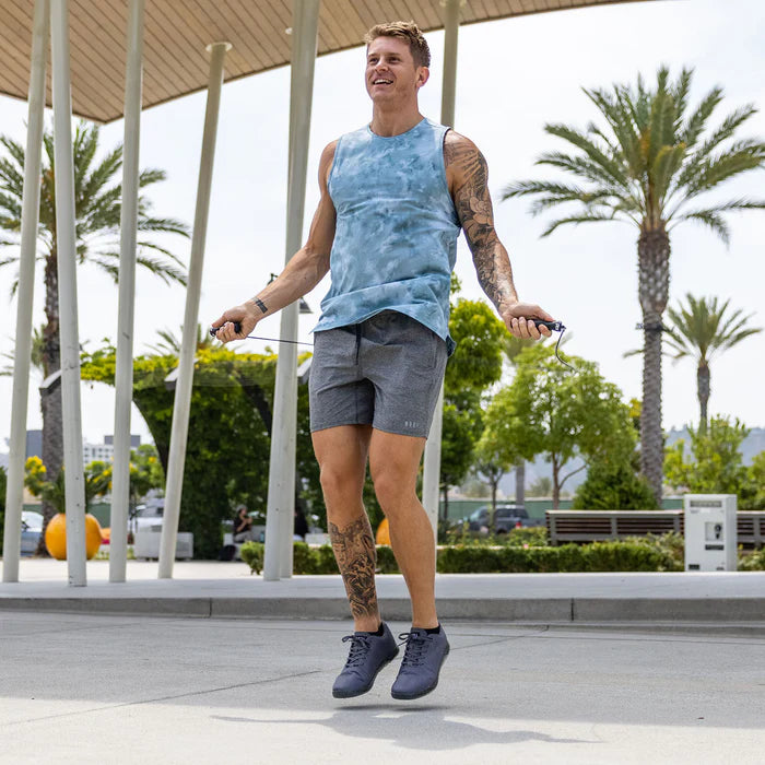 Man exercising with jump ropes outdoors on a sunny day