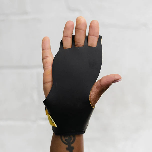 Black victory hand grip used for crossfit glove on a hand against a white background