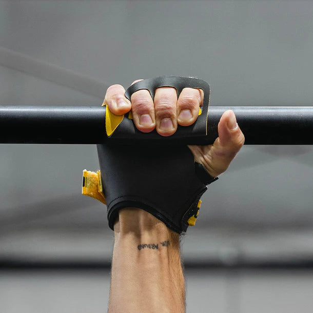 Hand wearing a black glove gripping a bar with a blurred background