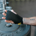 Person wearing a black wrist support on a gym weight plate