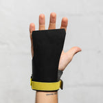 Black Victory hand grip with yellow strap on a gray background