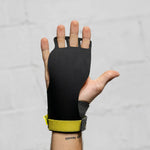 Black victory hand grips with yellow wrist strap on a gray background