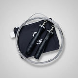 Black jump rope with metal clasps on a gray background