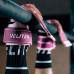 Close-up of hands gripping pull-up bar wearing pink Velites Quad Ultra no chalk CrossFit gymnastic grips in gym