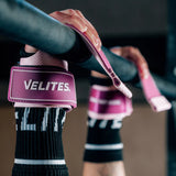 Close-up of hands gripping pull-up bar wearing pink Velites Quad Ultra no chalk CrossFit gymnastic grips in gym