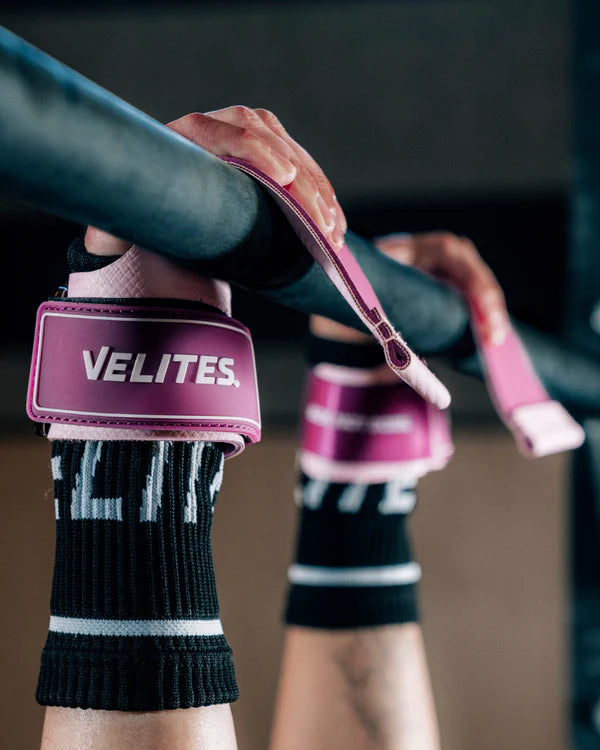 Close-up of hands gripping pull-up bar wearing pink Velites Quad Ultra no chalk CrossFit gymnastic grips in gym